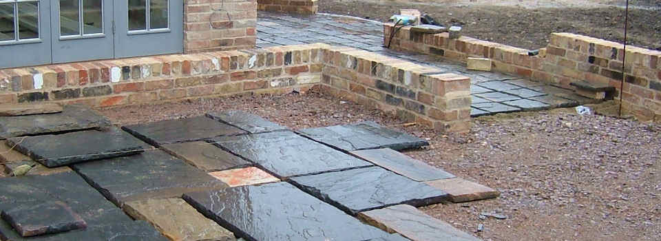 Groundworks and natural slate paved patio being laid